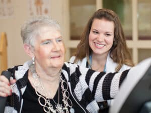 a rehab therapists helping an elderly woman in the rehab gym